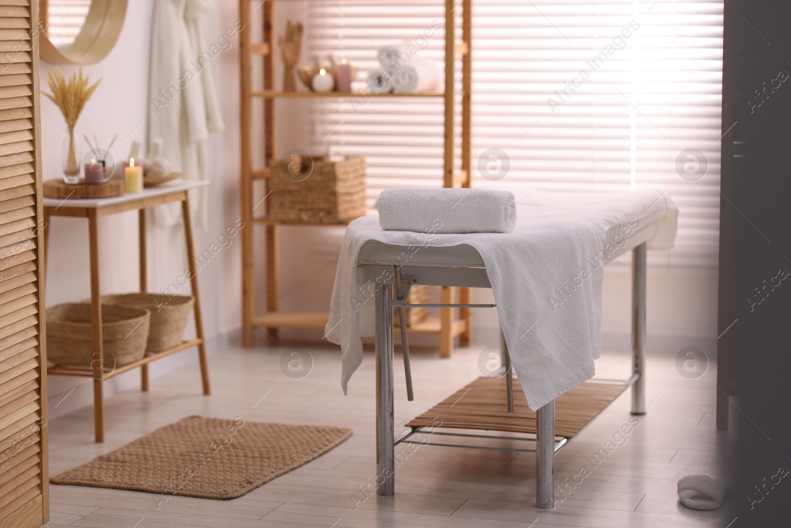 Photo of Comfortable massage table with clean towels in spa center