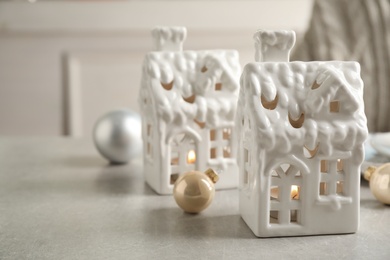 Photo of Composition with house shaped candle holders on light table. Christmas decoration