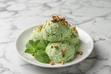Photo of Delicious pistachio ice cream on marble table