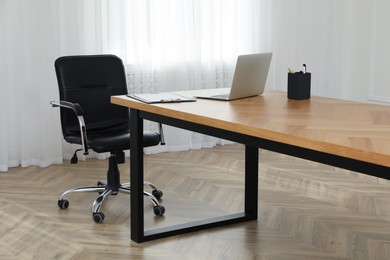 Photo of Director's office with large wooden table and comfortable armchair. Interior design