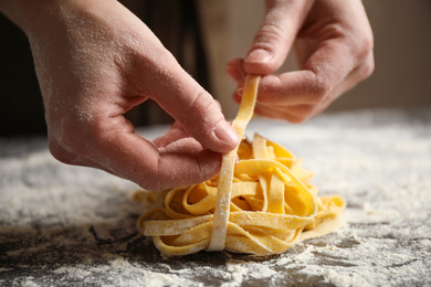 Woman holding pasta at table, closeup view