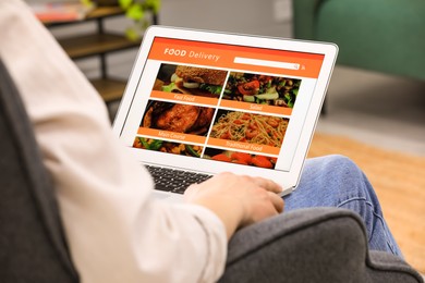 Photo of Man using laptop for ordering food online at home, closeup. Concept of delivery service