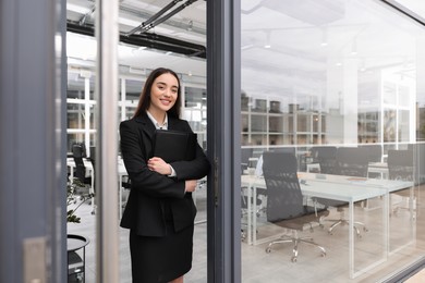 Photo of Female real estate agent with leather portfolio in office