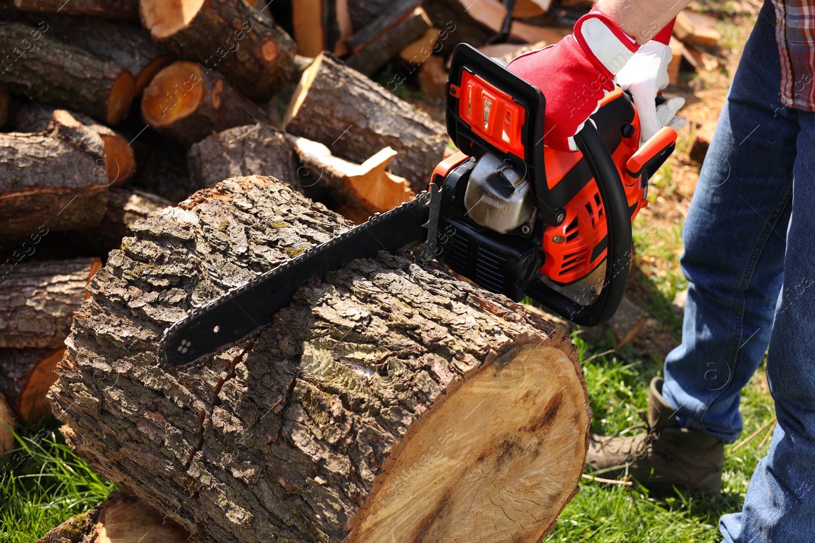 Photo of Man sawing wooden log on sunny day, closeup