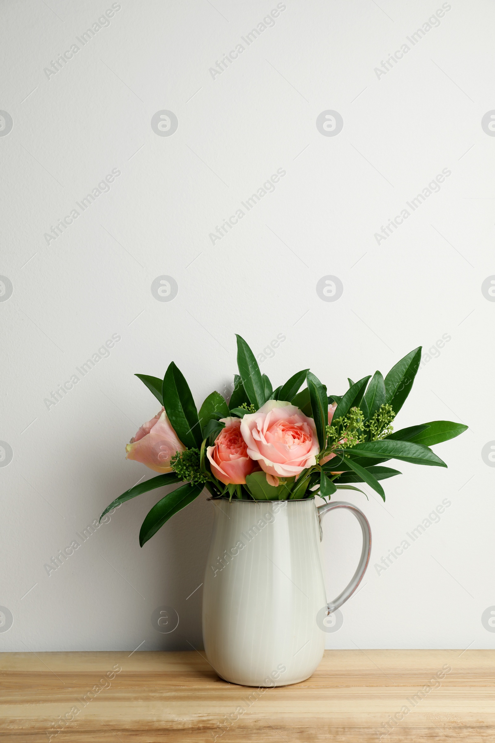 Photo of Bouquet of beautiful flowers in vase on wooden table against white background