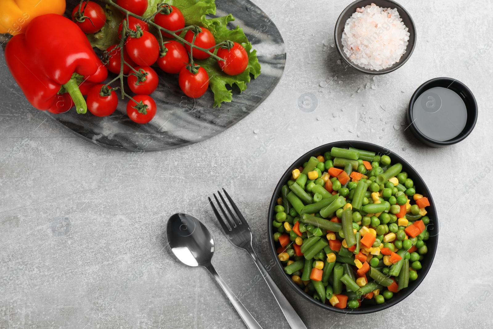 Photo of Mix of fresh vegetables served on grey table, flat lay