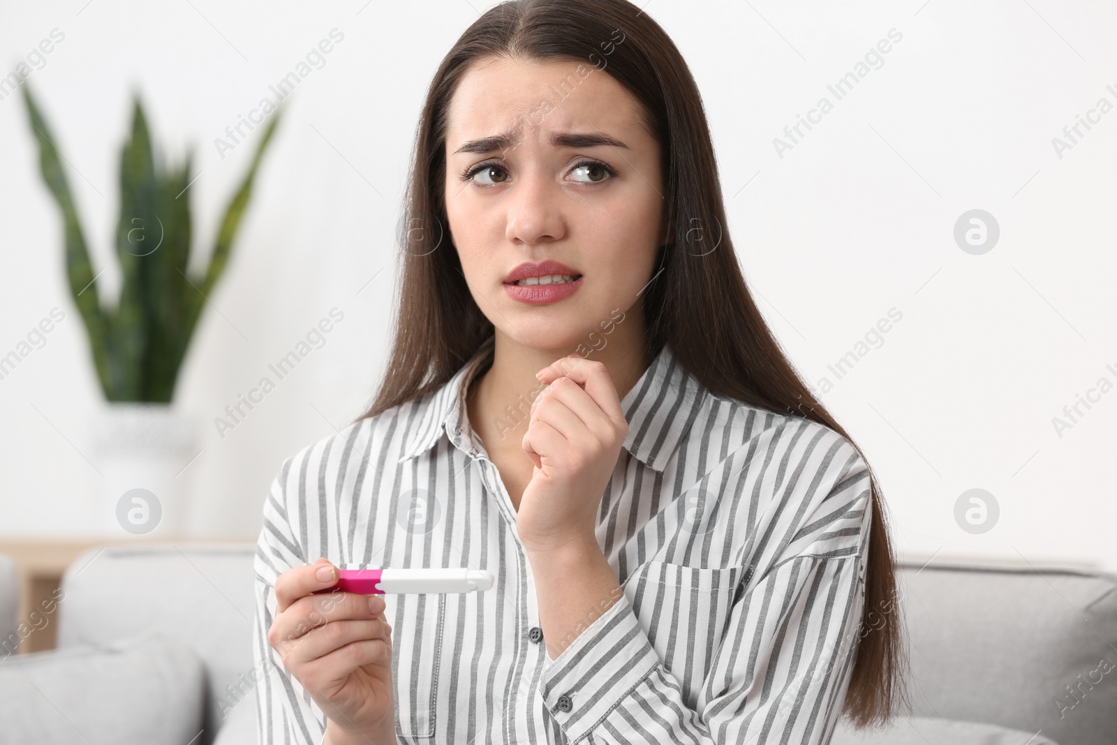 Photo of Young woman with pregnancy test at home. Gynecology and childbirth