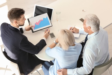 Photo of Male manager consulting mature couple in office