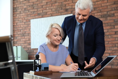 Senior notary working with client in office