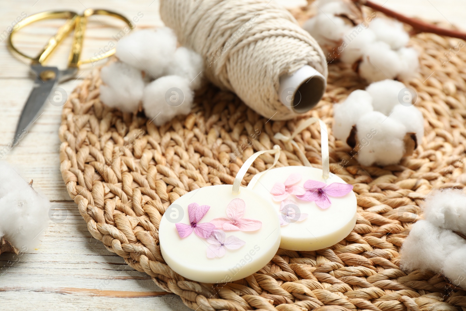 Photo of Composition with scented sachets and flowers on white wooden table