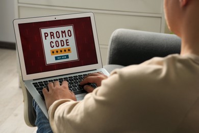 Photo of Man with laptop activating promo code while doing online shopping indoors, closeup