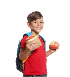 Schoolboy with healthy food and backpack on white background