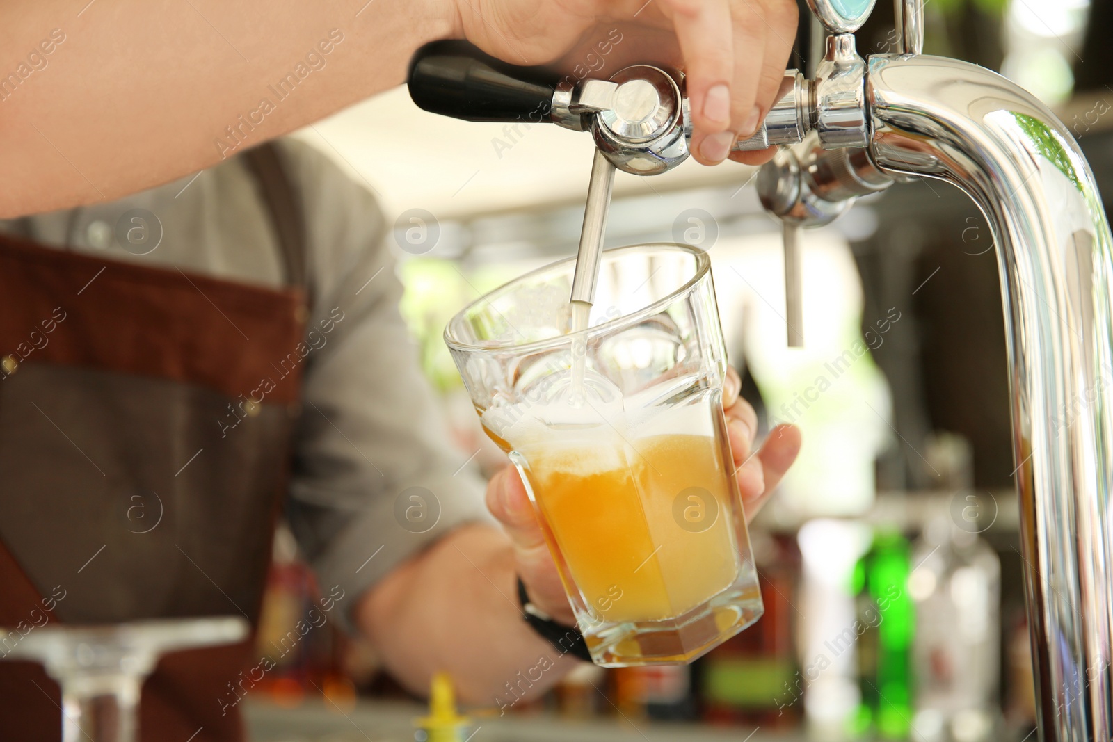 Photo of Bartender pouring fresh cold beer from tap, closeup