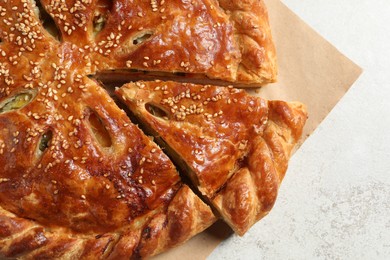 Photo of Cut delicious homemade pie on light grey table, top view