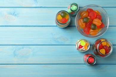 Photo of Delicious gummy candies on light blue wooden background, flat lay. Space for text