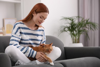 Photo of Woman with her cute cat on sofa at home