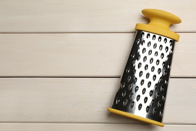 Photo of Modern grater on white wooden table, top view. Space for text