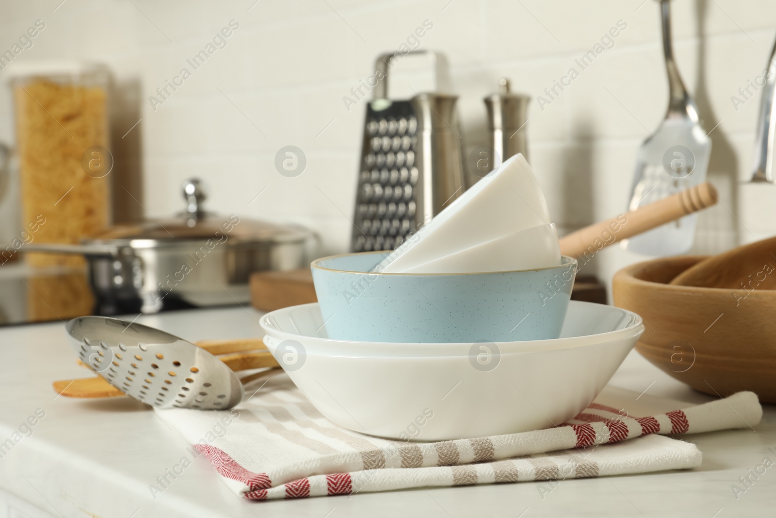 Photo of Stack of bowls and different cooking utensils on kitchen counter