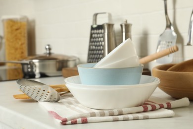 Stack of bowls and different cooking utensils on kitchen counter