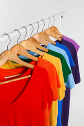 Photo of Colorful clothes on hangers against white background