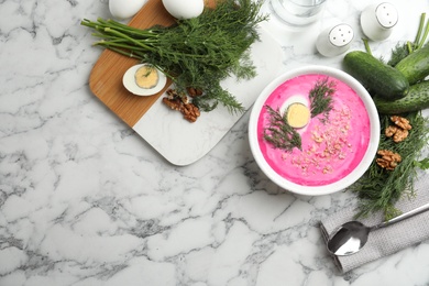 Photo of Delicious cold summer beet soup on white marble table, flat lay. Space for text