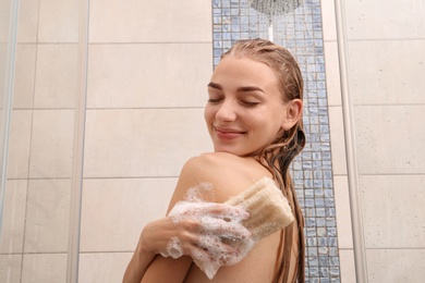 Beautiful young woman taking shower at home