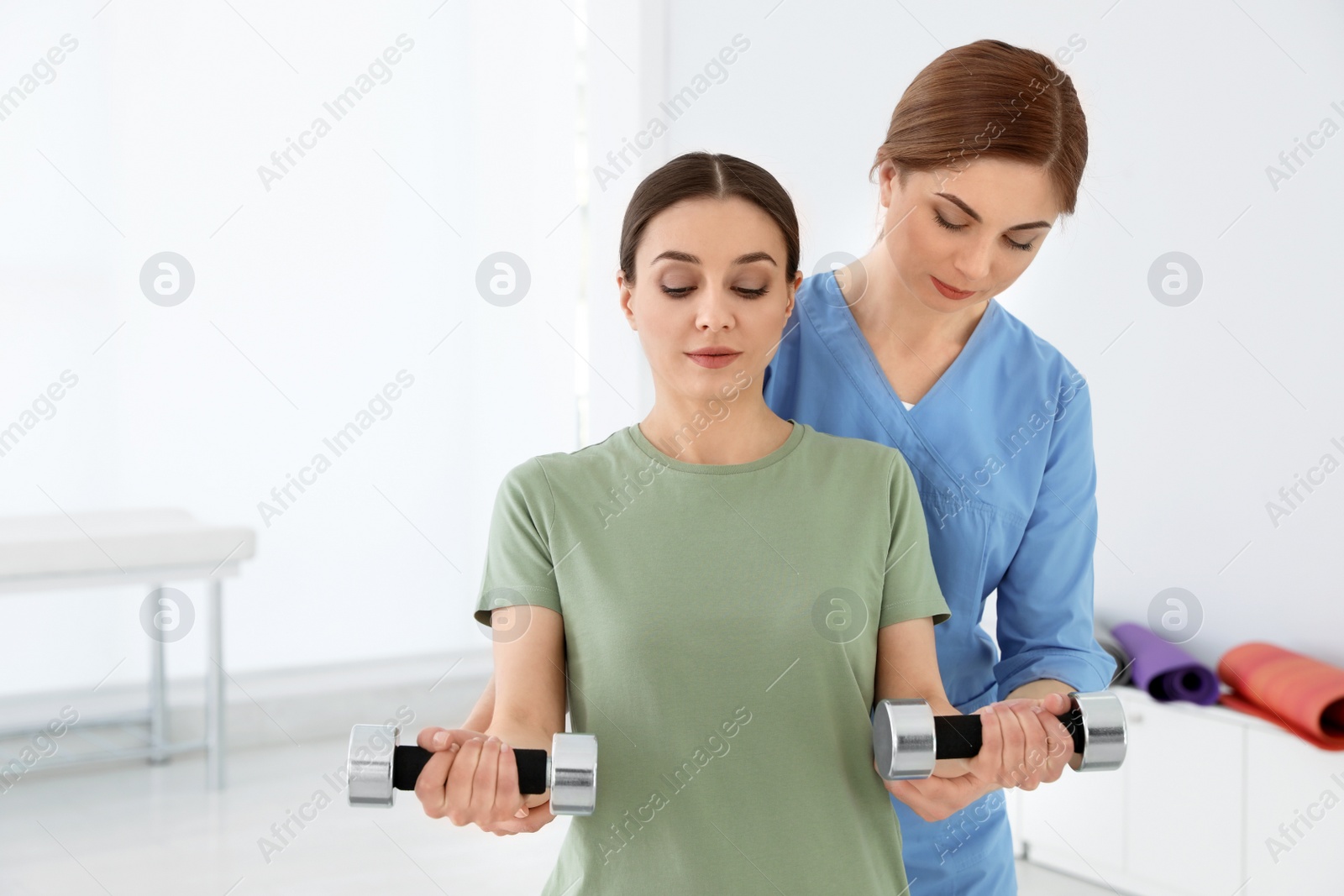 Photo of Professional physiotherapist working with female patient in rehabilitation center