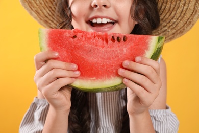 Photo of Cute little girl with watermelon on yellow background, closeup