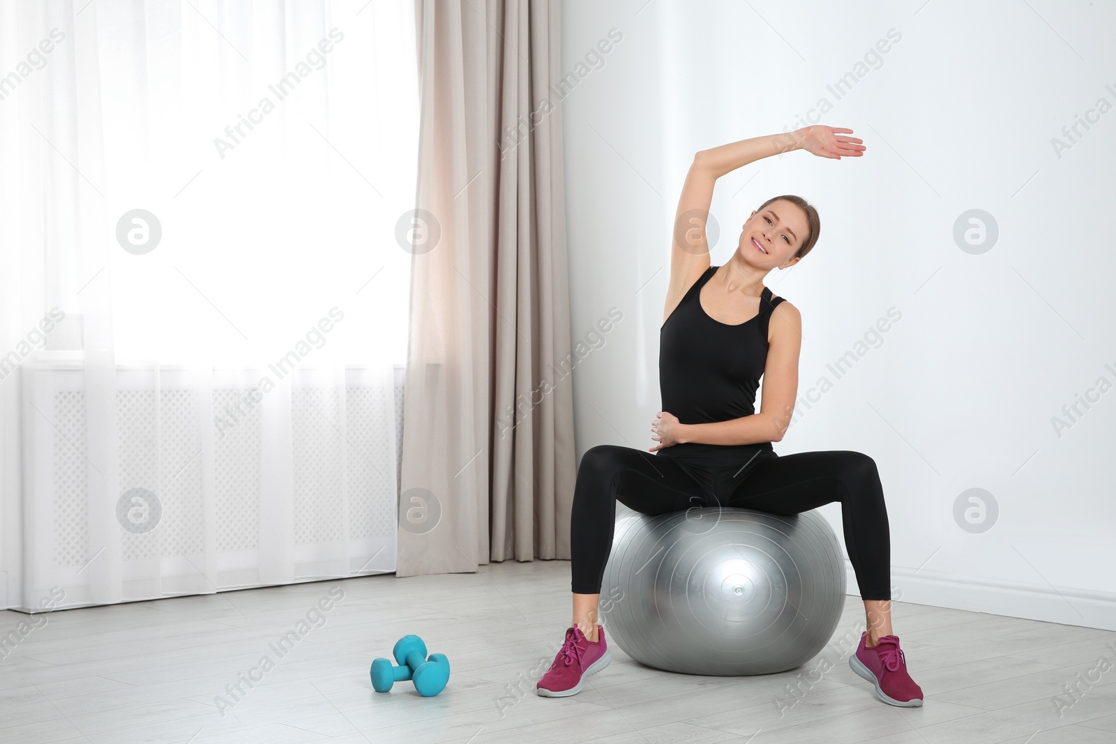 Photo of Young woman doing fitness exercises at home. Space for text