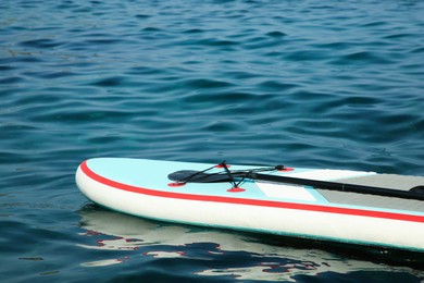 Photo of One SUP board with paddle on sea water