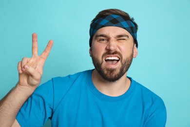 Photo of Fashionable young man wearing stylish bandana on light blue background