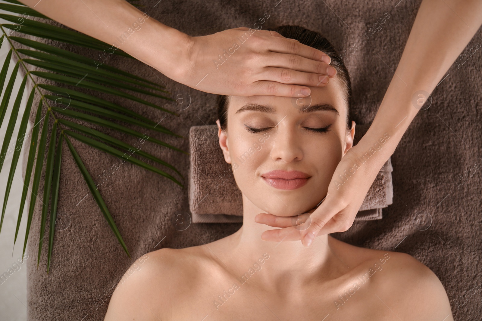 Photo of Beautiful young woman enjoying massage in spa salon, top view