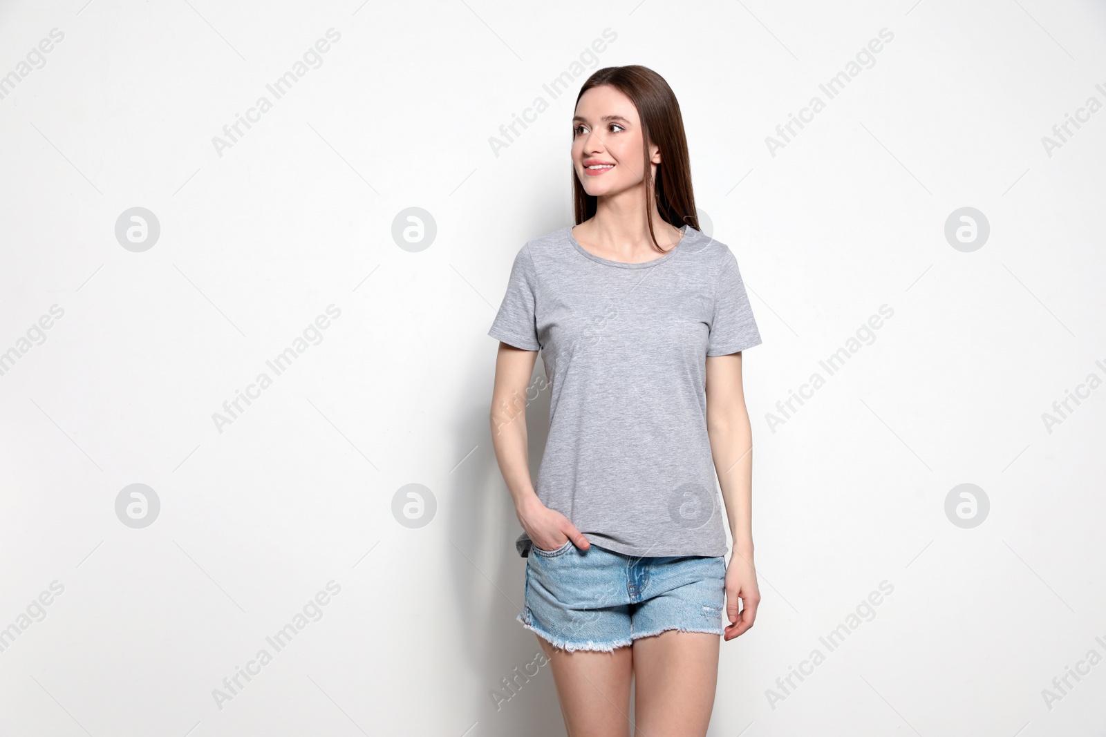 Photo of Young woman in t-shirt on light background. Mock up for design