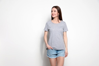 Young woman in t-shirt on light background. Mock up for design