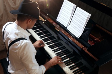 Photo of Man playing piano indoors, above view. Talented musician