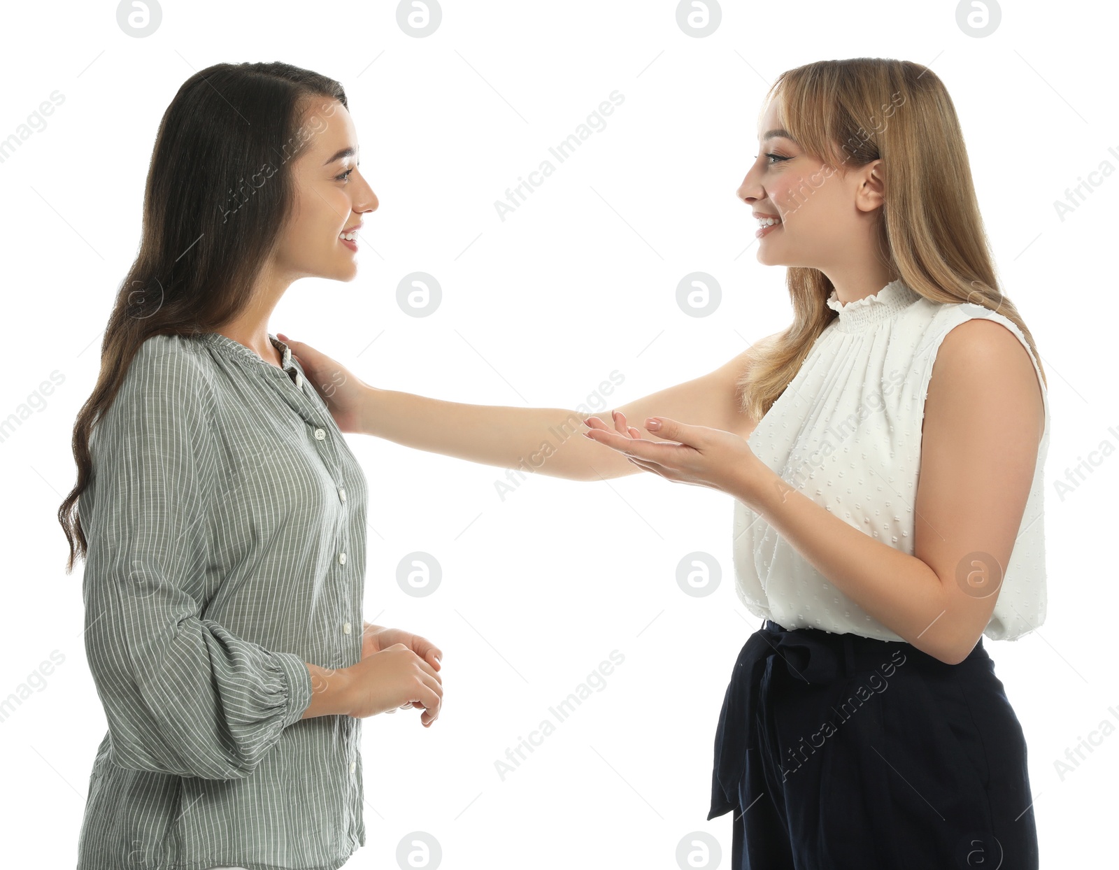 Photo of Young women in casual clothes talking on white background