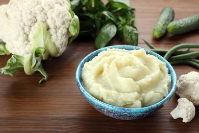 Bowl with tasty puree and ingredients on wooden table