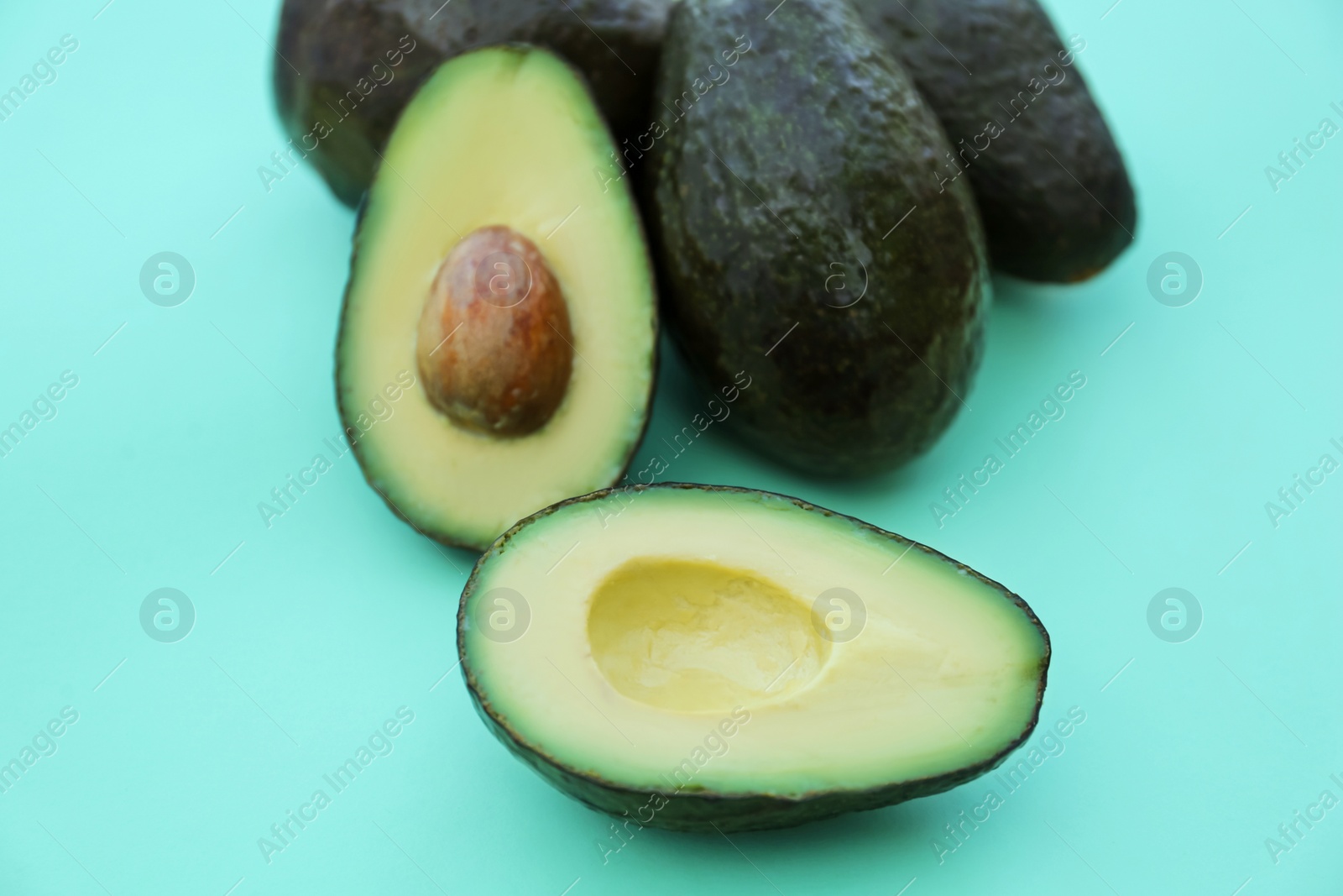 Photo of Tasty fresh ripe avocados on turquoise background