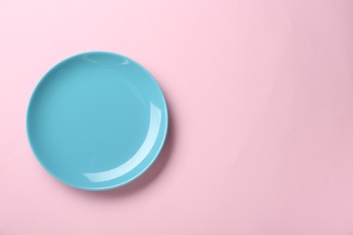 Photo of Clean light blue plate on pink background, top view. Space for text