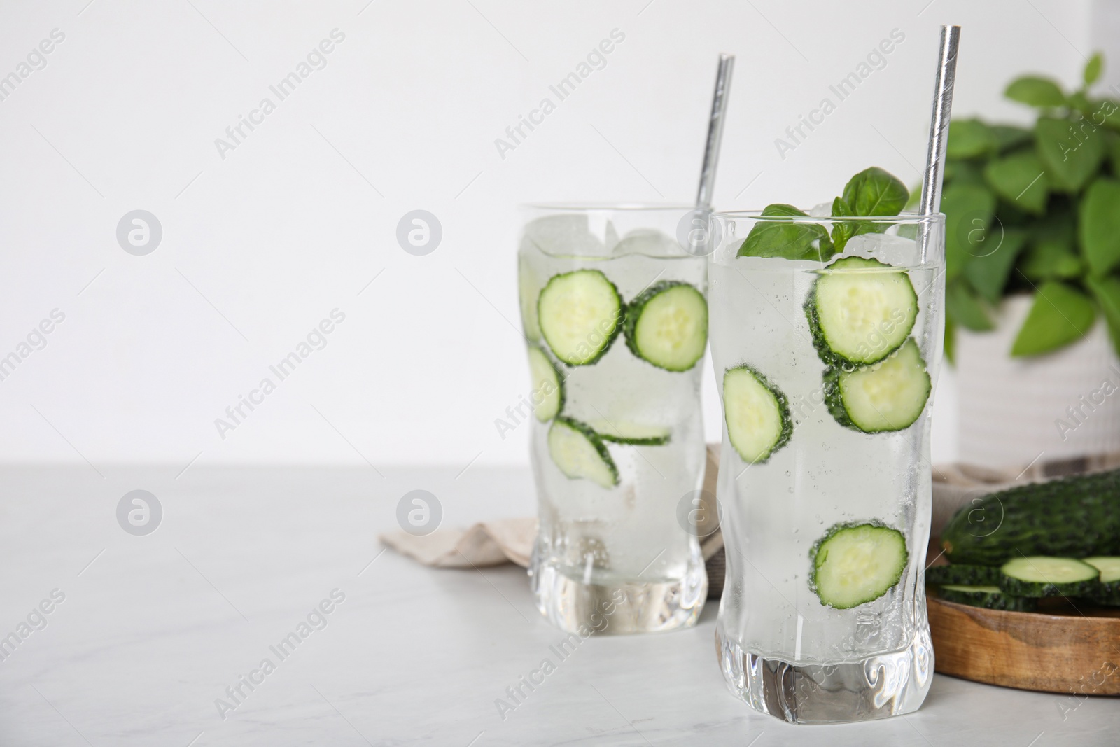 Photo of Tasty fresh cucumber water on white table. Space for text