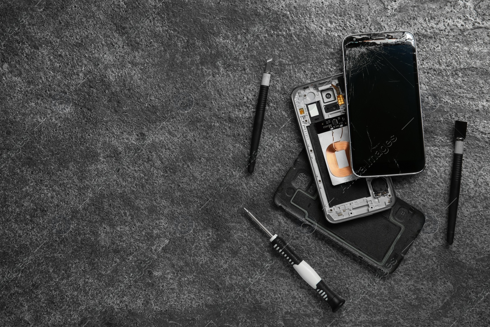 Photo of Damaged smartphone and repair tools on grey background, flat lay. Space for text