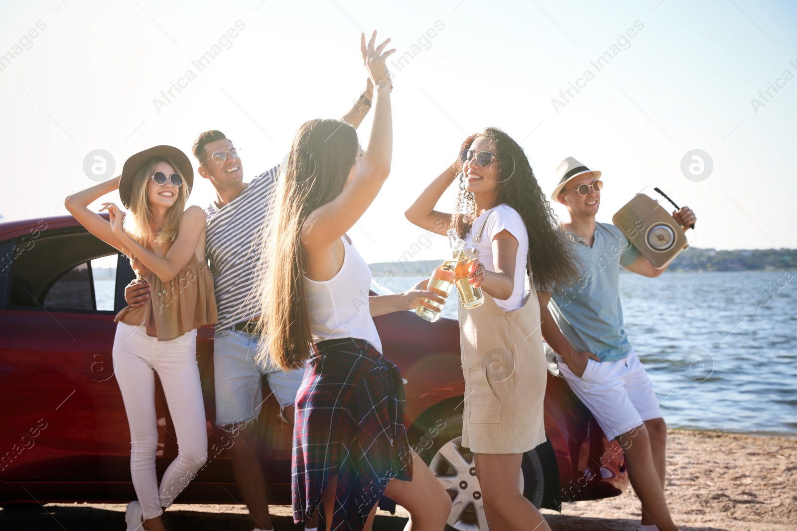 Photo of Happy friends having fun near car on beach. Summer trip