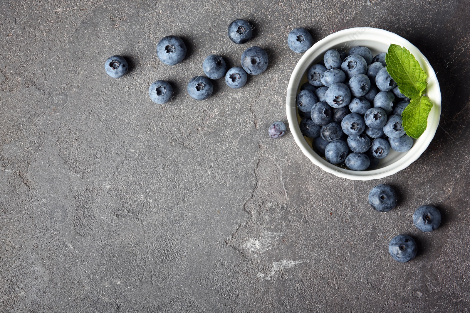 Photo of Flat lay composition with juicy and fresh blueberries on color table. Space for text