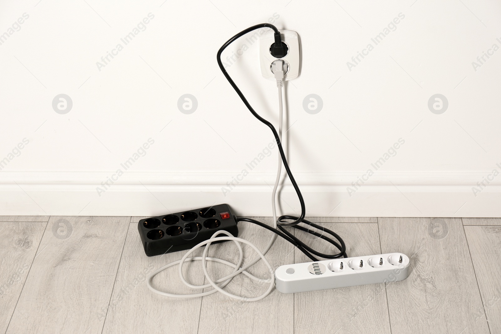 Photo of Extension cords with power plugs in socket indoors. Electrician's professional equipment