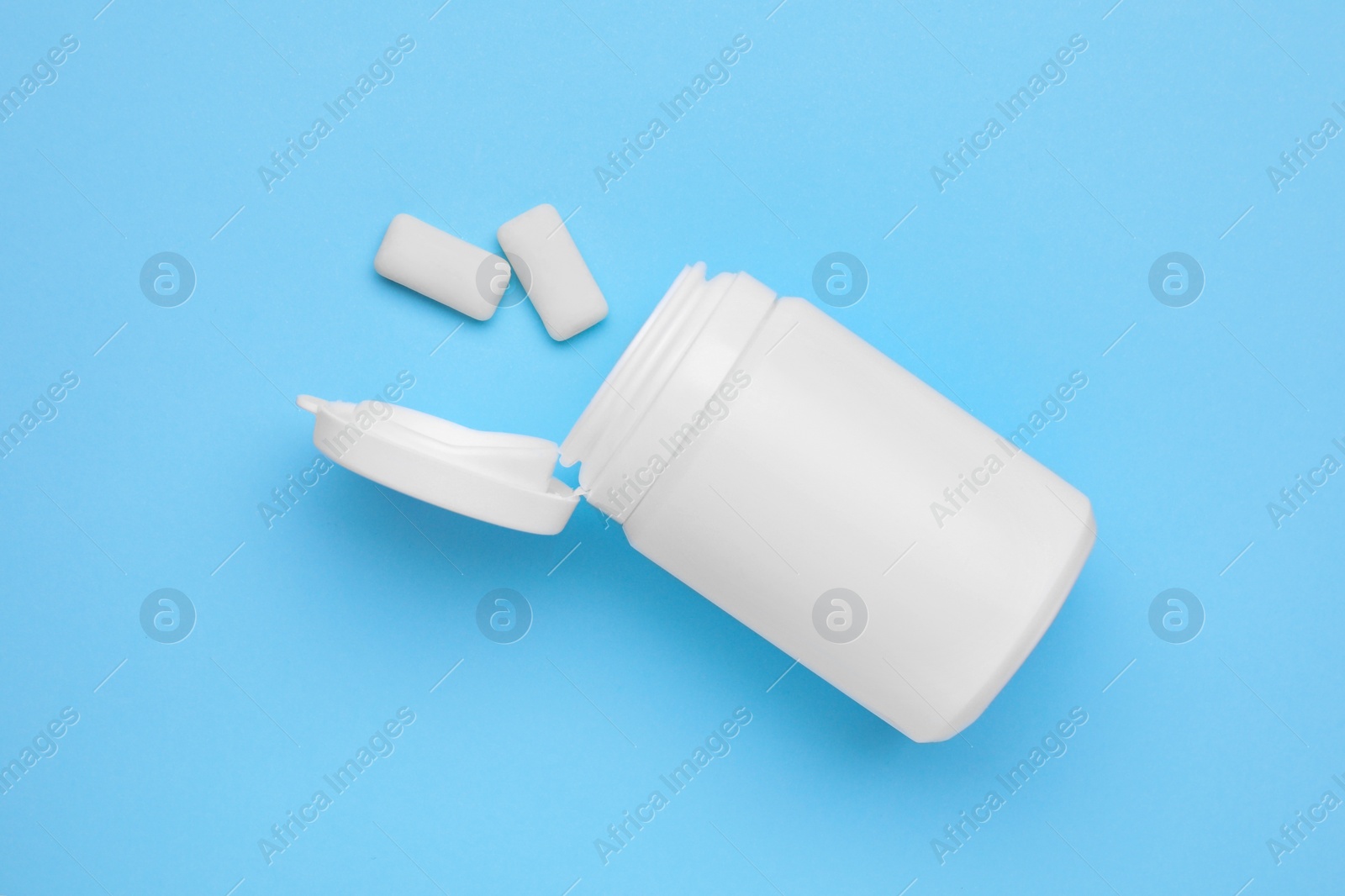 Photo of Jar with chewing gums on light blue background, flat lay