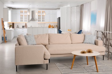 Photo of Stylish studio apartment interior with comfortable beige sofa