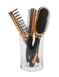 Set of professional hair brushes in glass holder isolated on white