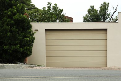 Photo of Beige garage with closed sectional door. Exterior design