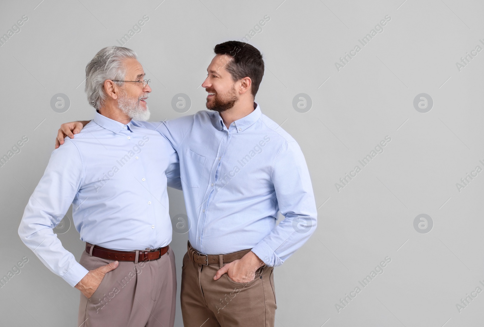 Photo of Happy son and his dad on gray background, space for text