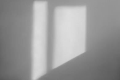 Photo of Light and shadow from window on beige wall indoors